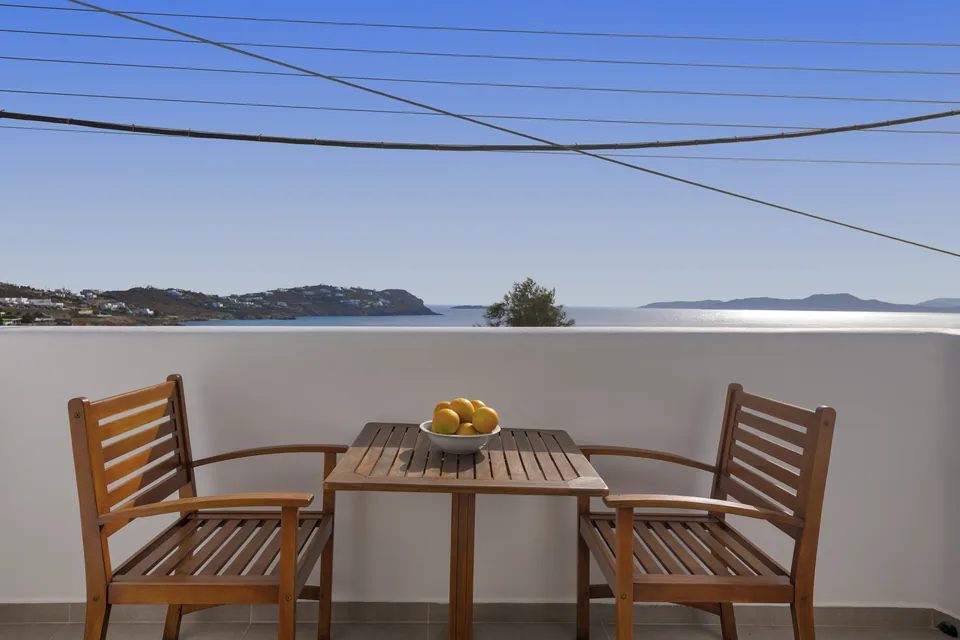 Two chairs and a table on the sea view veranda of Suite 103