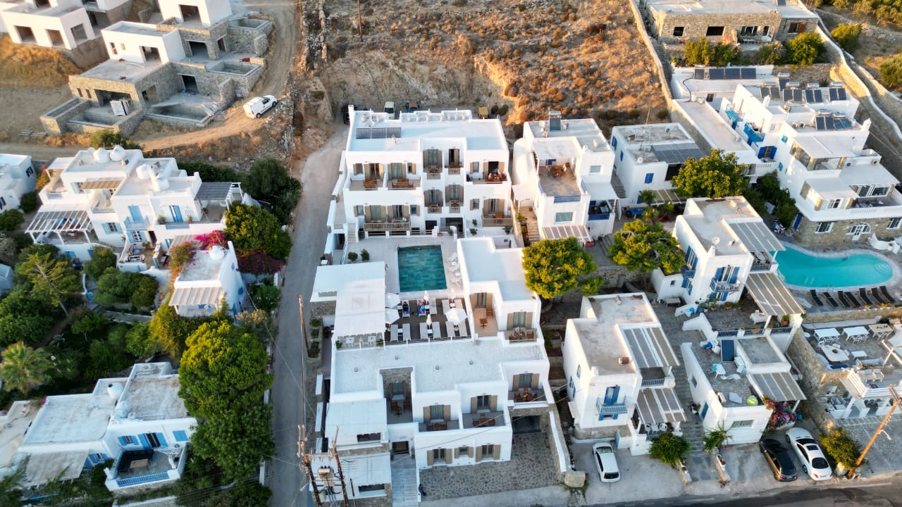 Aerial view of Lithos by Spyros & Flora, with its buildings and central swimming pool in Agios Ioannis, Mykonos